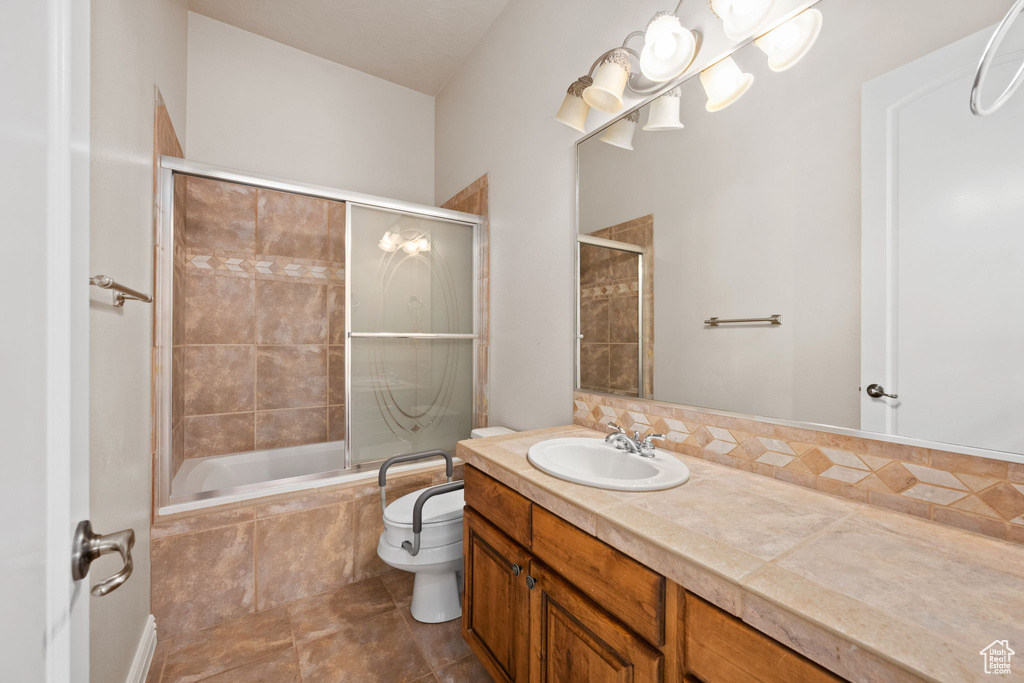 Full bath with vanity, tiled shower / bath, toilet, and tile patterned flooring