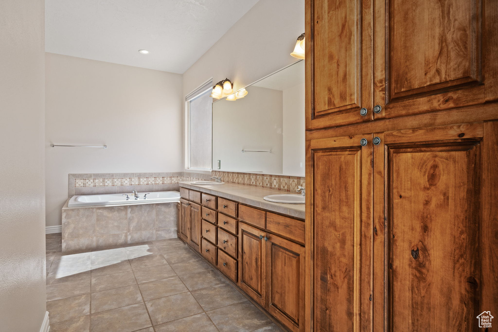 Full bathroom featuring a garden tub, tile patterned flooring, and double vanity