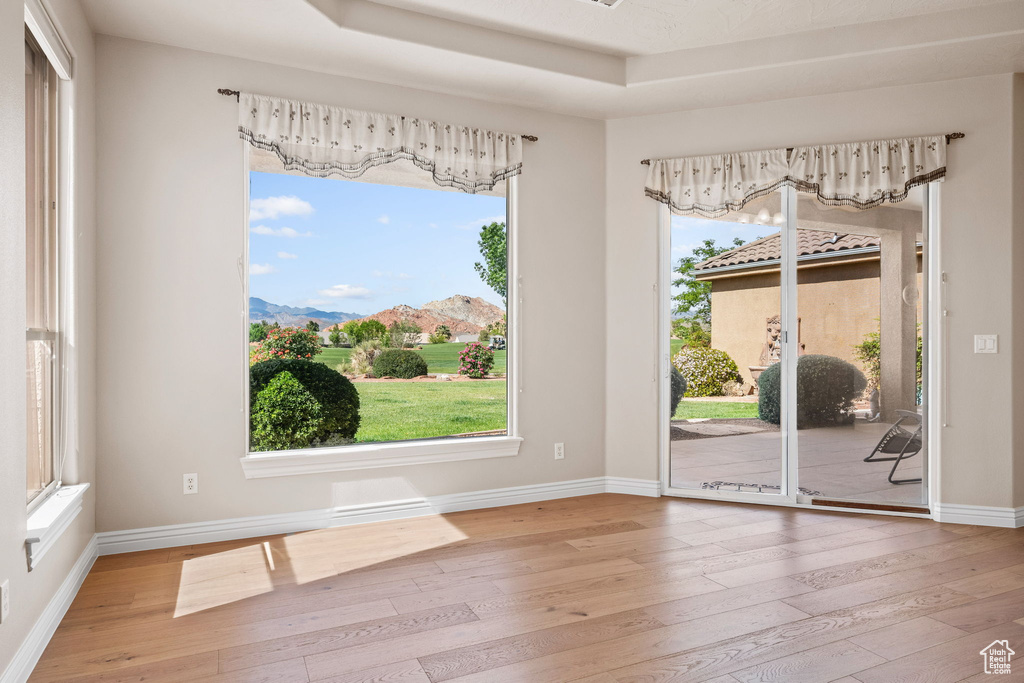 Spare room with hardwood / wood-style flooring, a mountain view, plenty of natural light, and baseboards