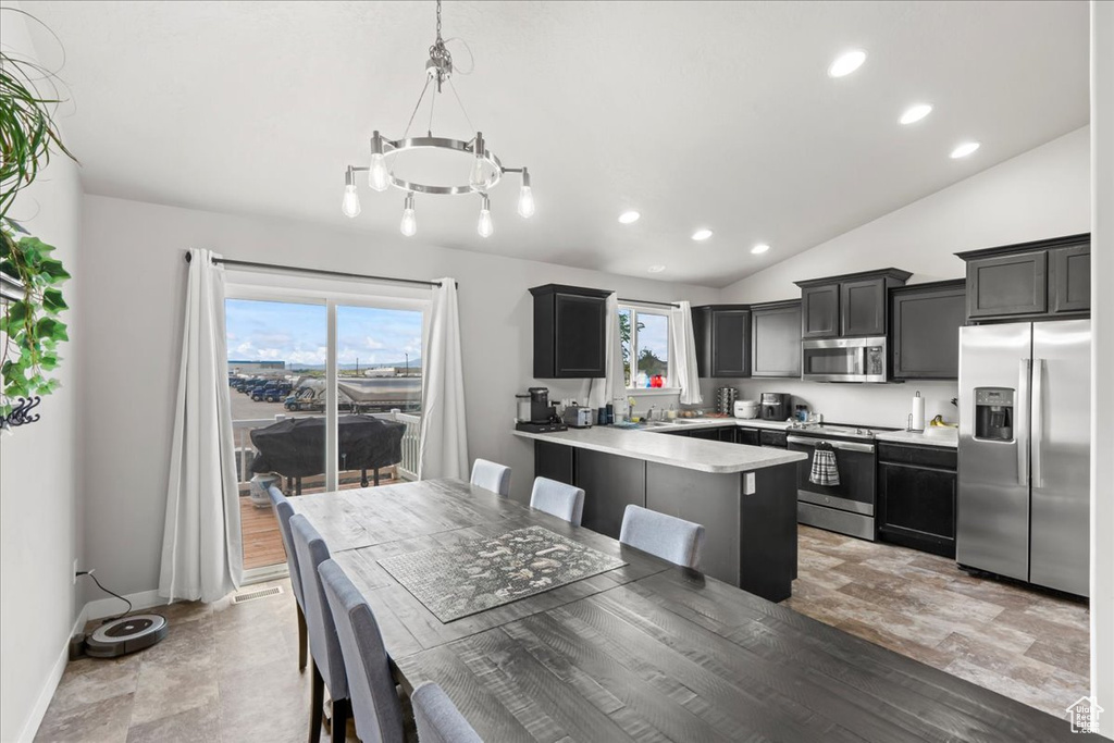 Dining area with baseboards, lofted ceiling, recessed lighting, and a chandelier