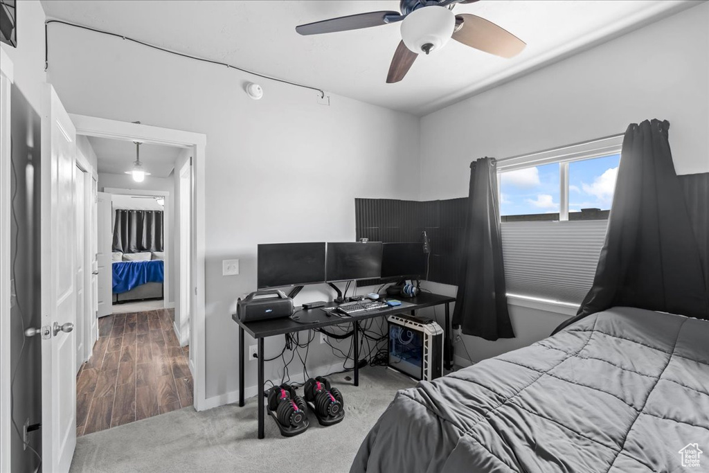 Carpeted bedroom featuring a ceiling fan