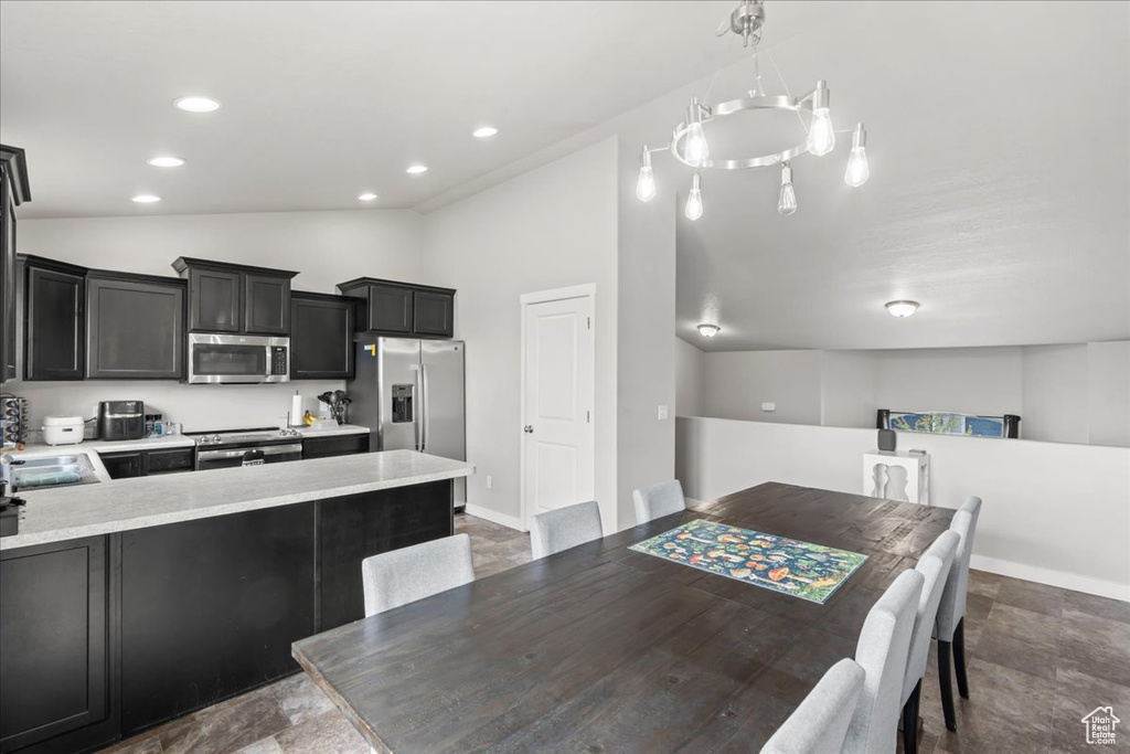 Dining room featuring baseboards, stone finish floor, vaulted ceiling, and recessed lighting