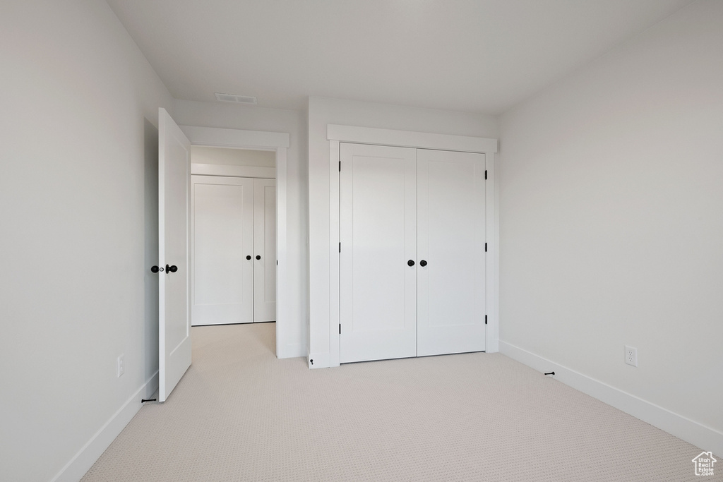 Unfurnished bedroom featuring carpet floors, baseboards, and a closet