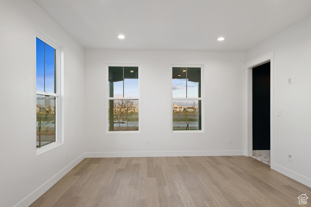 Spare room with light wood finished floors, healthy amount of natural light, baseboards, and recessed lighting