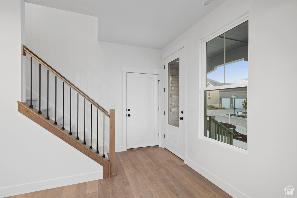 Foyer with wood finished floors, stairs, and baseboards