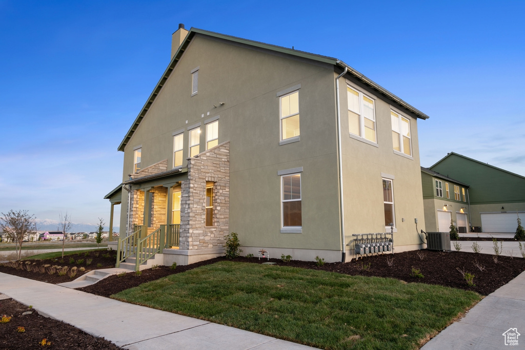 View of property exterior with stucco siding, a lawn, a chimney, and cooling unit