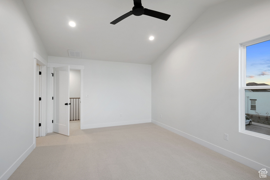 Carpeted spare room featuring ceiling fan, lofted ceiling, recessed lighting, and baseboards