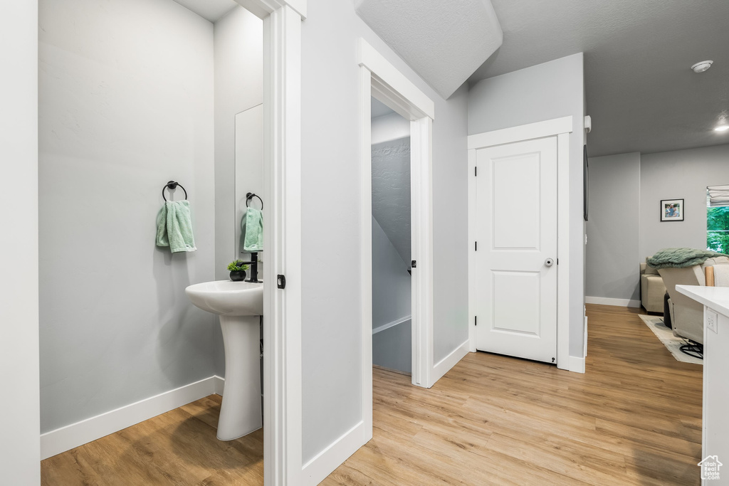 Bathroom featuring wood finished floors, baseboards, and a sink