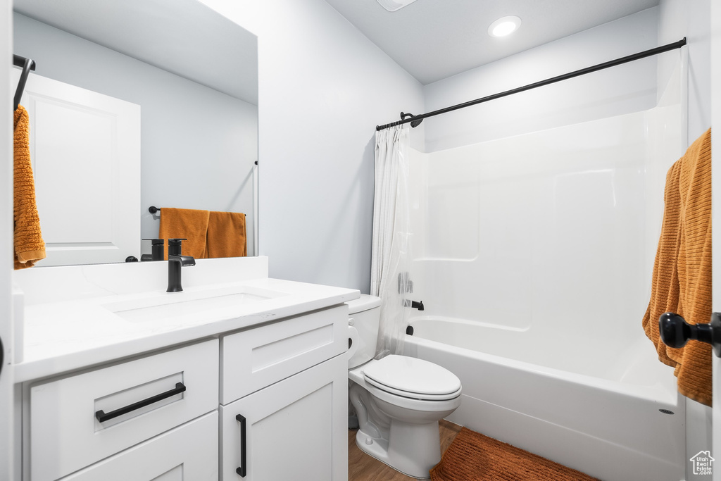Full bath featuring toilet, vanity, shower / bath combo with shower curtain, and recessed lighting