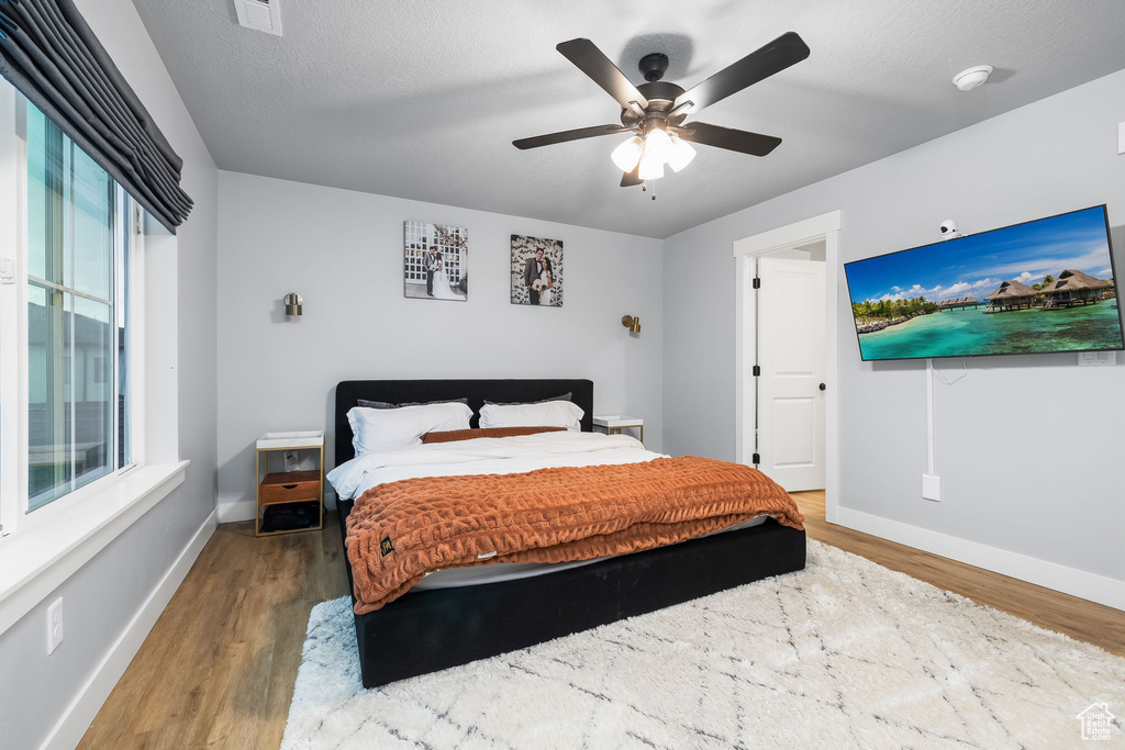 Bedroom with wood finished floors, baseboards, and ceiling fan