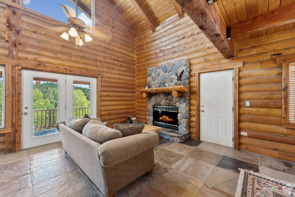 Living area featuring beamed ceiling, wood ceiling, high vaulted ceiling, a fireplace, and a ceiling fan