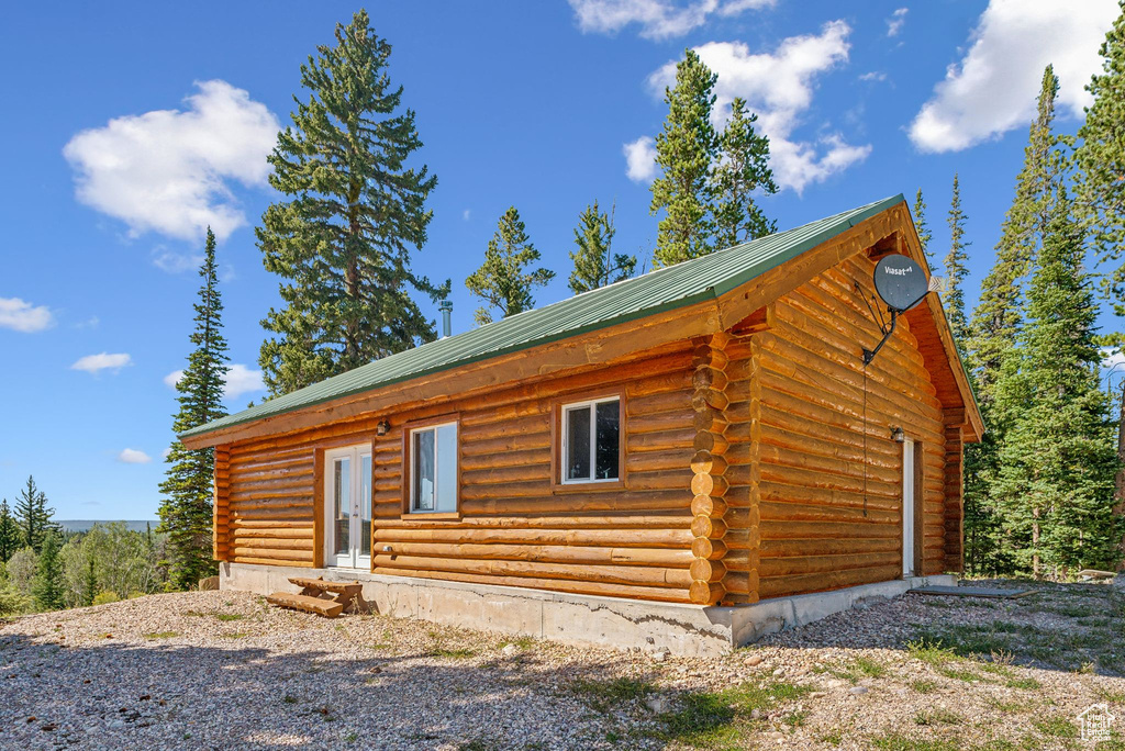 View of front of property with log siding and metal roof