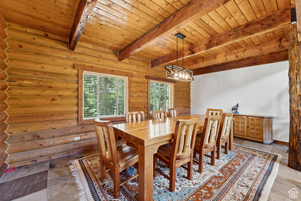 Dining room with wood ceiling, beam ceiling, log walls, and a chandelier