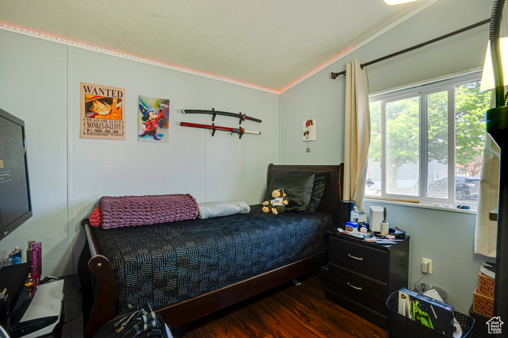 Bedroom with crown molding and dark wood finished floors