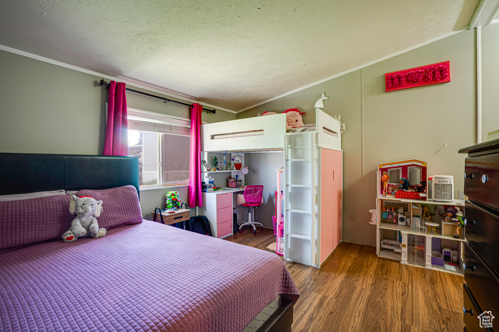 Bedroom featuring wood finished floors and ornamental molding