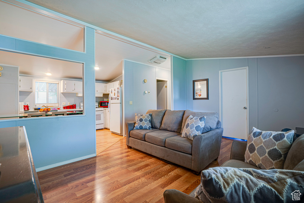Living area featuring light wood-style floors and ornamental molding