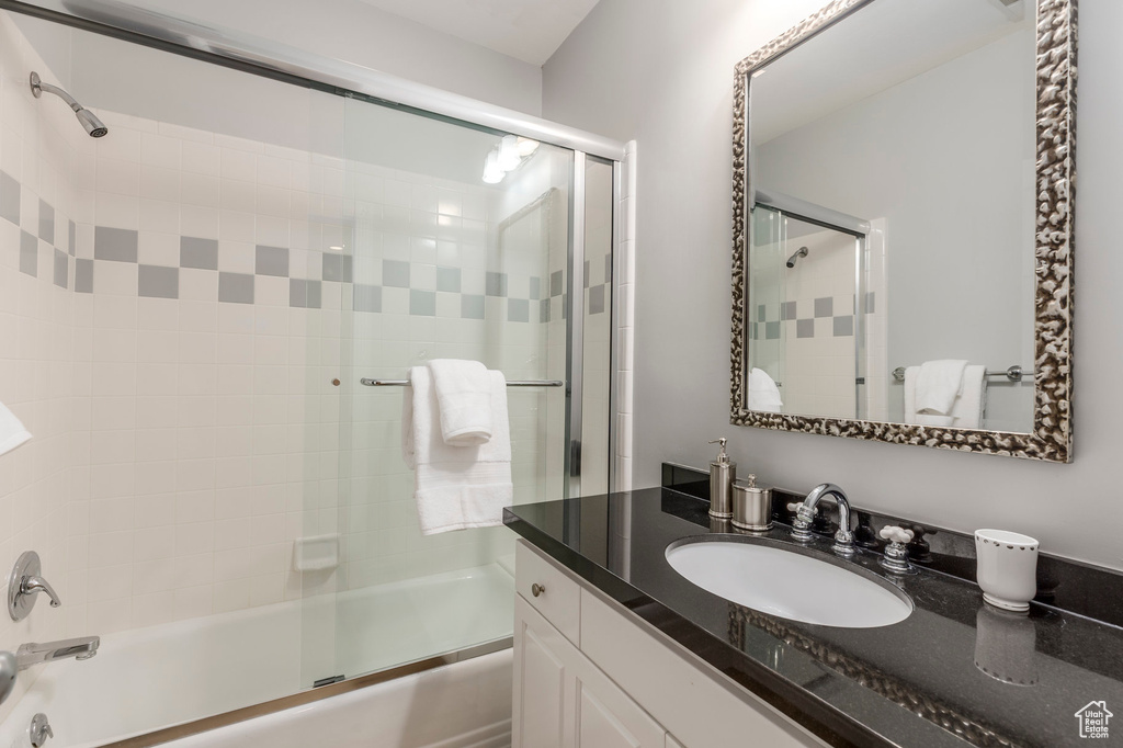 Full bathroom with combined bath / shower with glass door and vanity