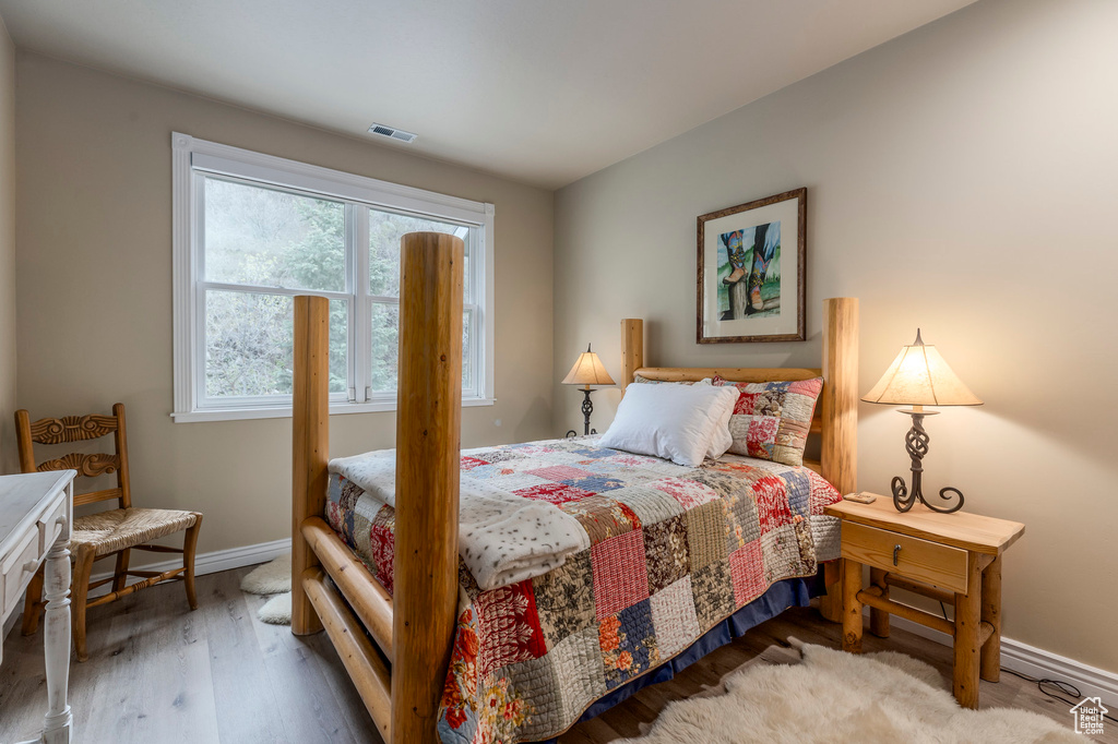Bedroom with wood finished floors and baseboards