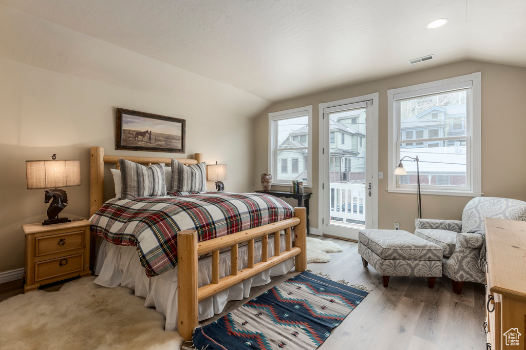 Bedroom featuring lofted ceiling, access to exterior, light wood-style flooring, baseboards, and recessed lighting