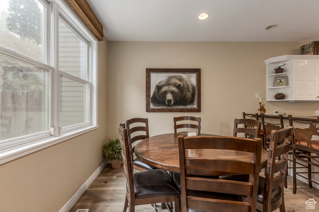Dining room featuring light wood-style floors, baseboards, and recessed lighting