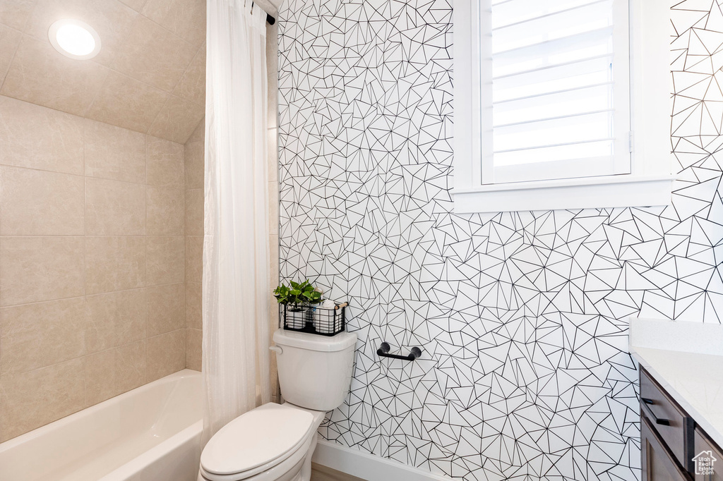 Full bath with toilet, vanity, shower / bathtub combination with curtain, and tile walls