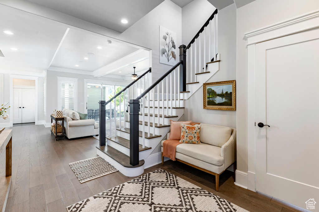 Staircase with wood finished floors, baseboards, crown molding, recessed lighting, and ceiling fan