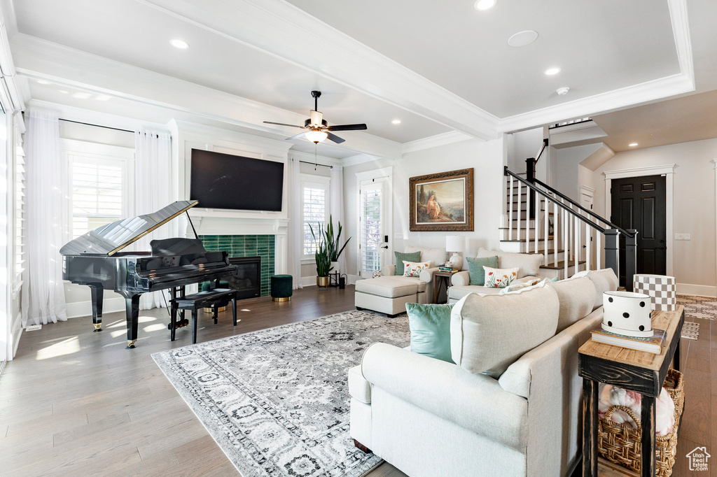 Living room with plenty of natural light, stairway, crown molding, ceiling fan, and baseboards
