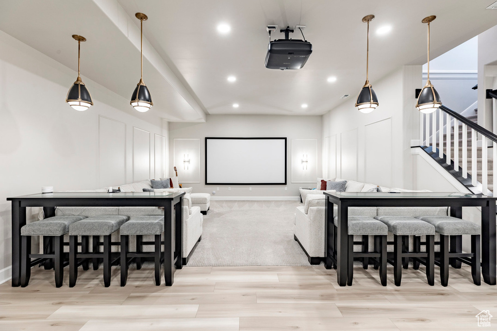 Home theater room featuring light wood-style floors, a decorative wall, and recessed lighting