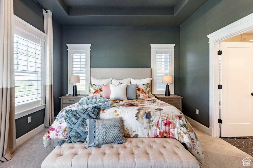 Bedroom featuring carpet, multiple windows, and baseboards