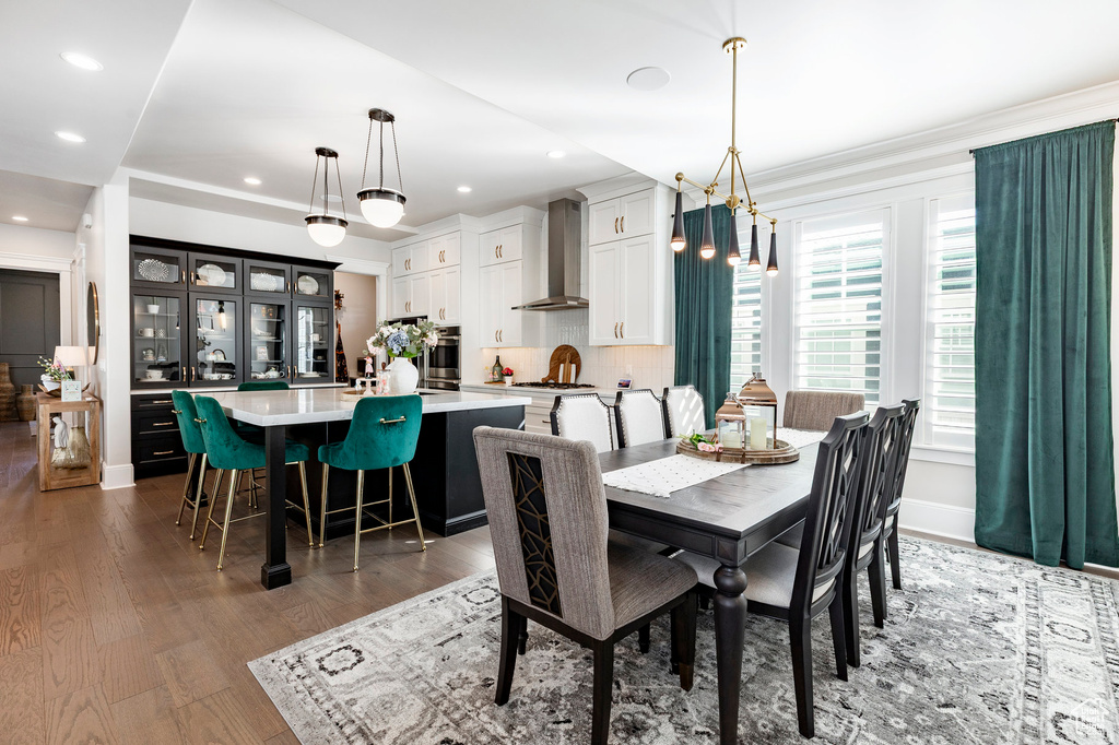 Dining room featuring wood finished floors, recessed lighting, ornamental molding, and baseboards