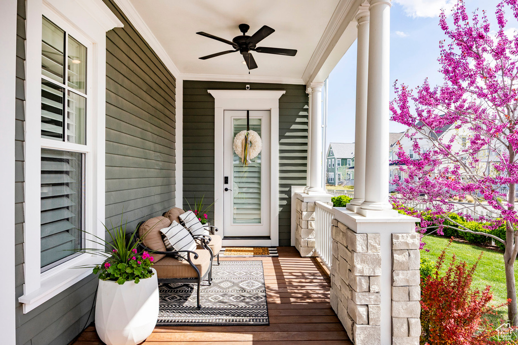 Doorway to property featuring covered porch and ceiling fan