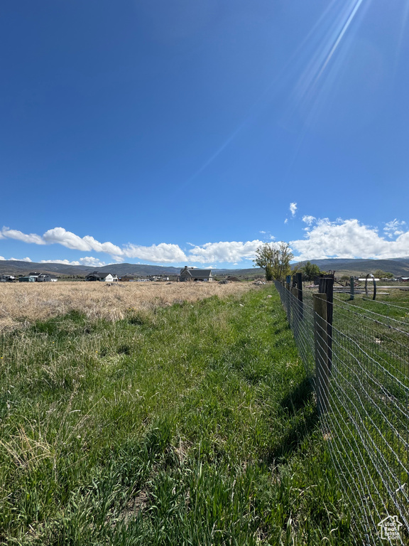 View of yard with a view of countryside and fence