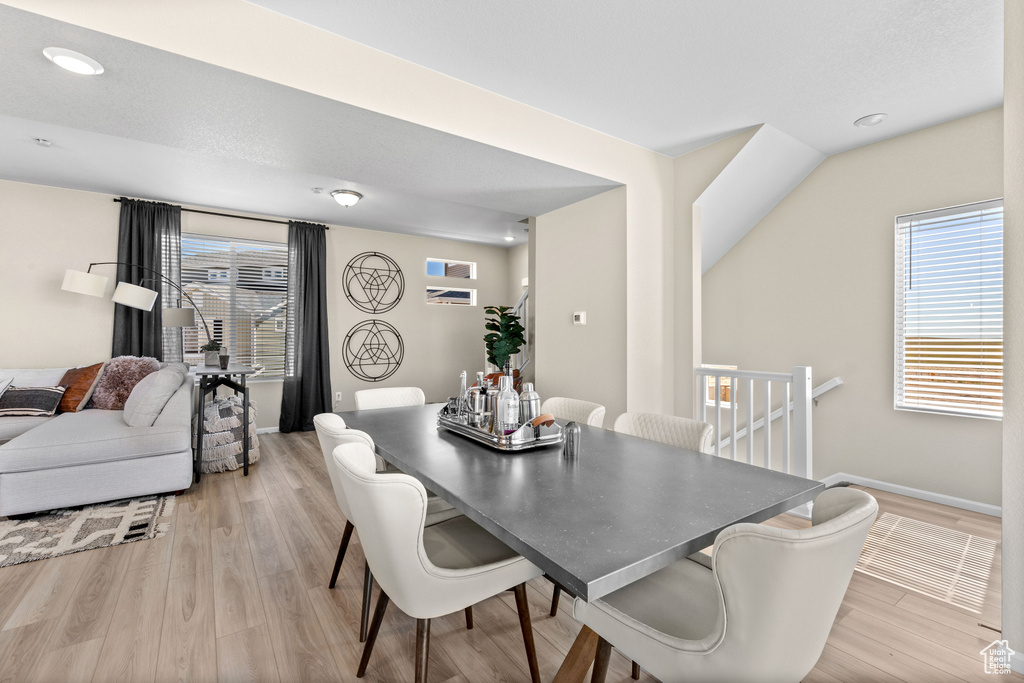 Dining room with light wood-style floors, baseboards, and recessed lighting