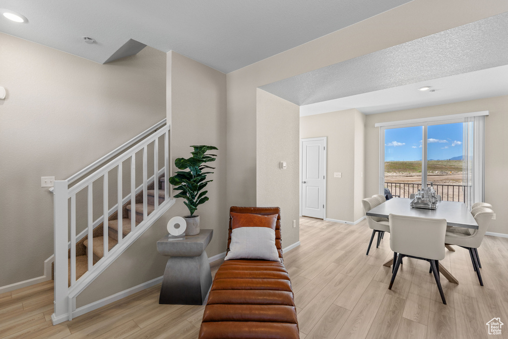 Dining space featuring light wood finished floors, stairway, baseboards, and recessed lighting