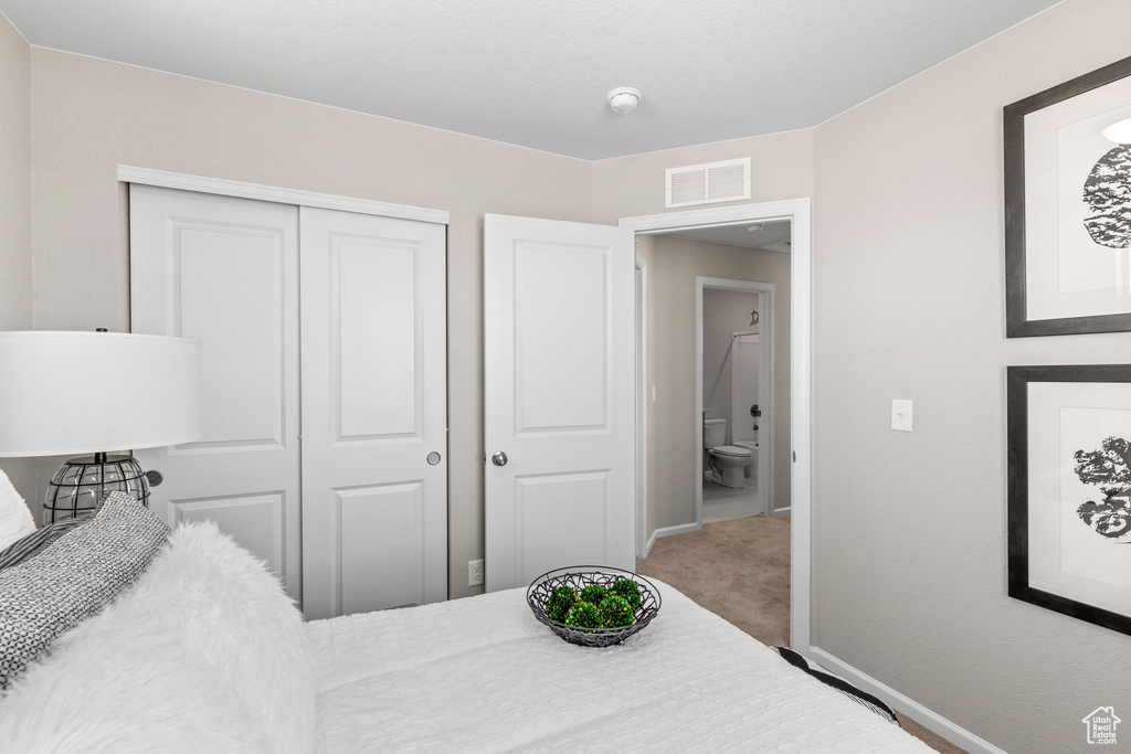 Bedroom featuring a closet, baseboards, and carpet floors