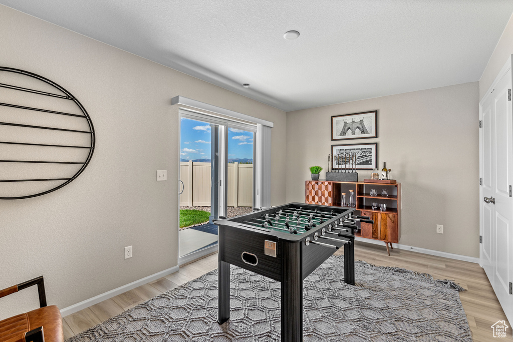 Recreation room with light wood finished floors and baseboards