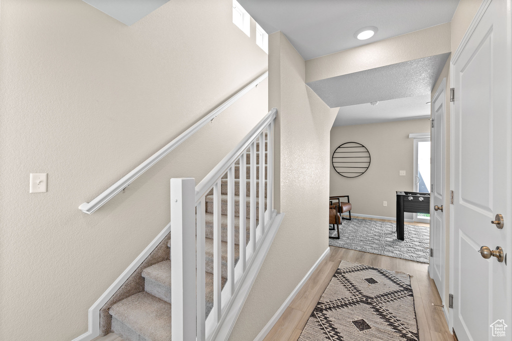 Stairway with baseboards and wood finished floors