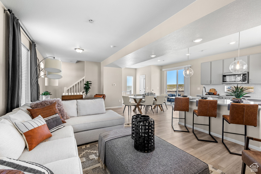 Living area with light wood-style flooring, stairway, and recessed lighting