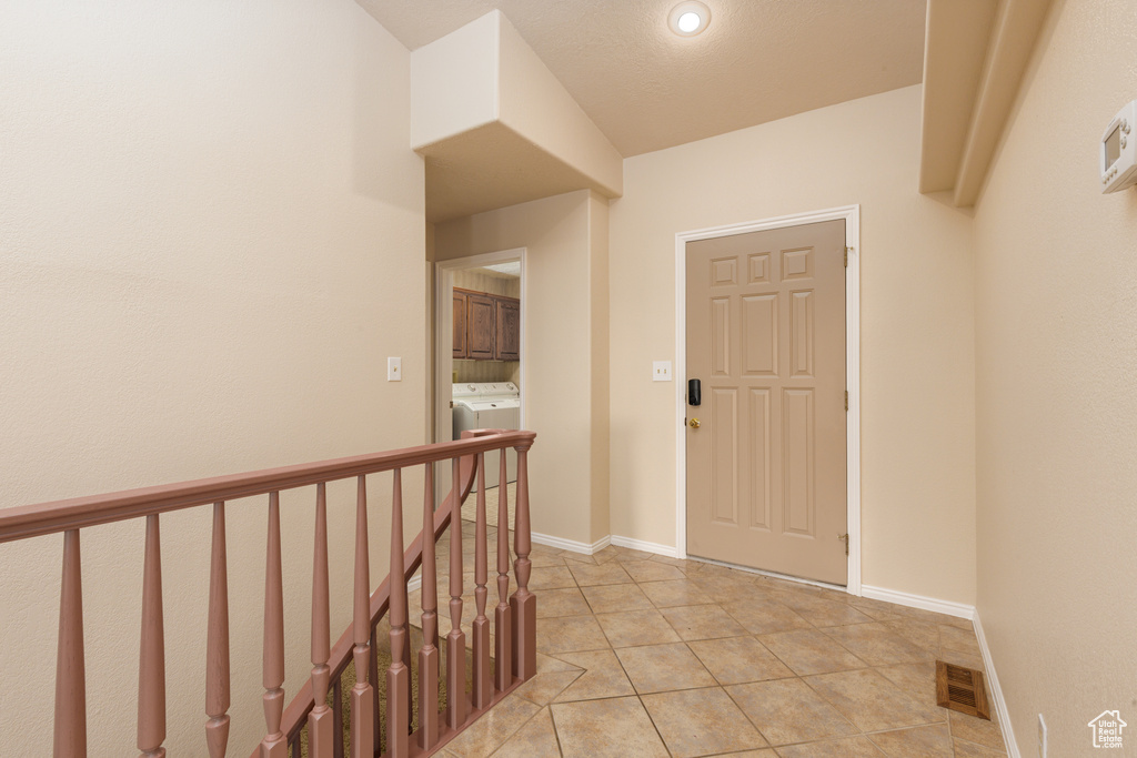 Foyer with washer / clothes dryer, light tile patterned floors, baseboards, and recessed lighting