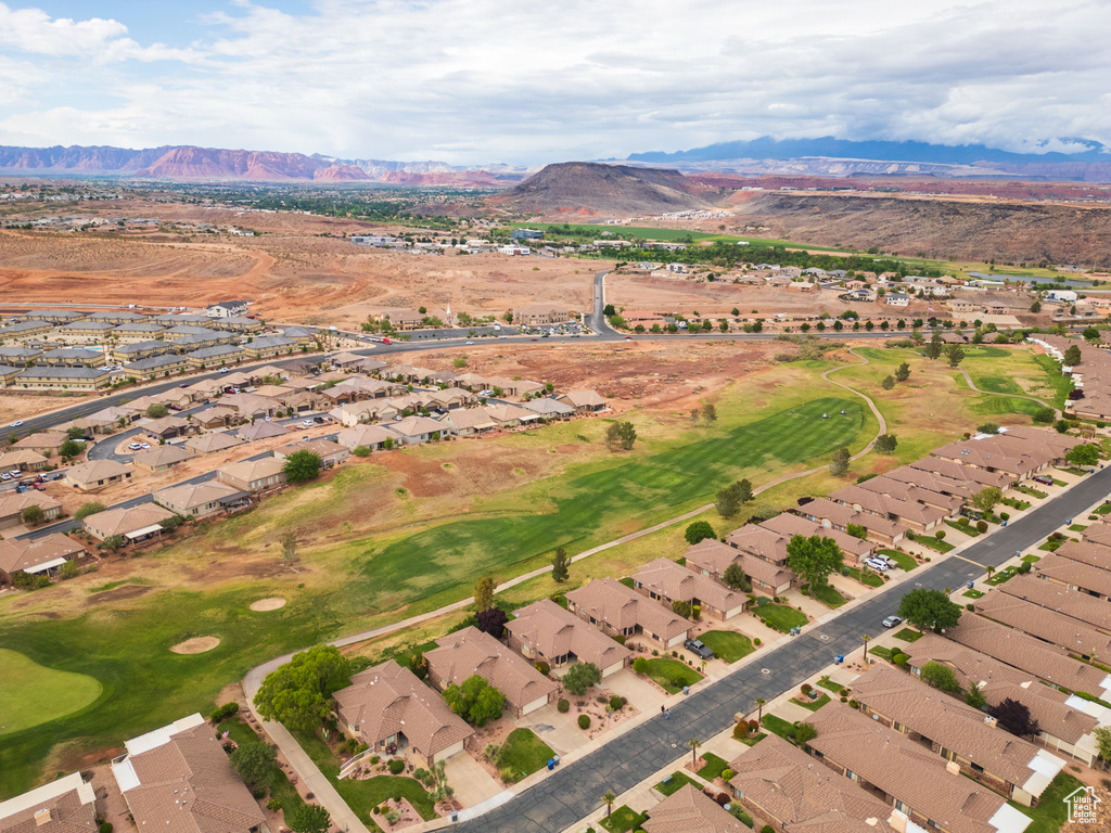Aerial view of property's location with nearby suburban area, mountains, and a golf club