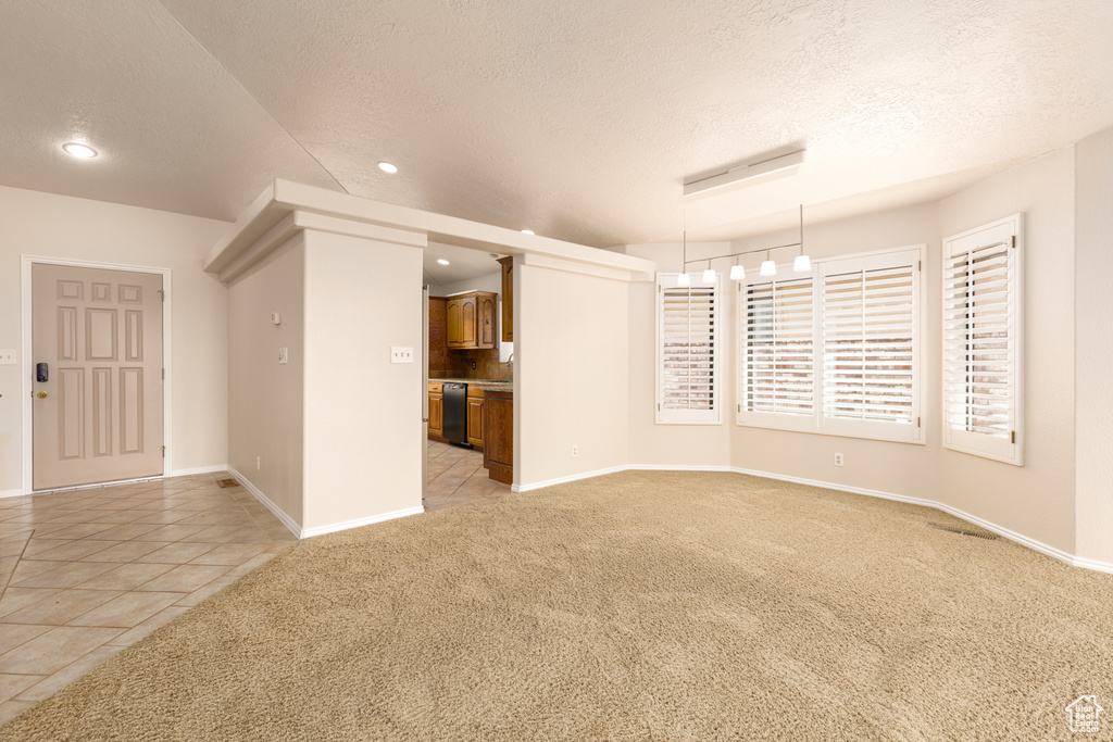 Spare room featuring light carpet, a textured ceiling, recessed lighting, baseboards, and light tile patterned flooring