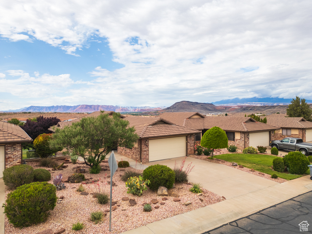 Single story home with a tile roof, concrete driveway, and an attached garage