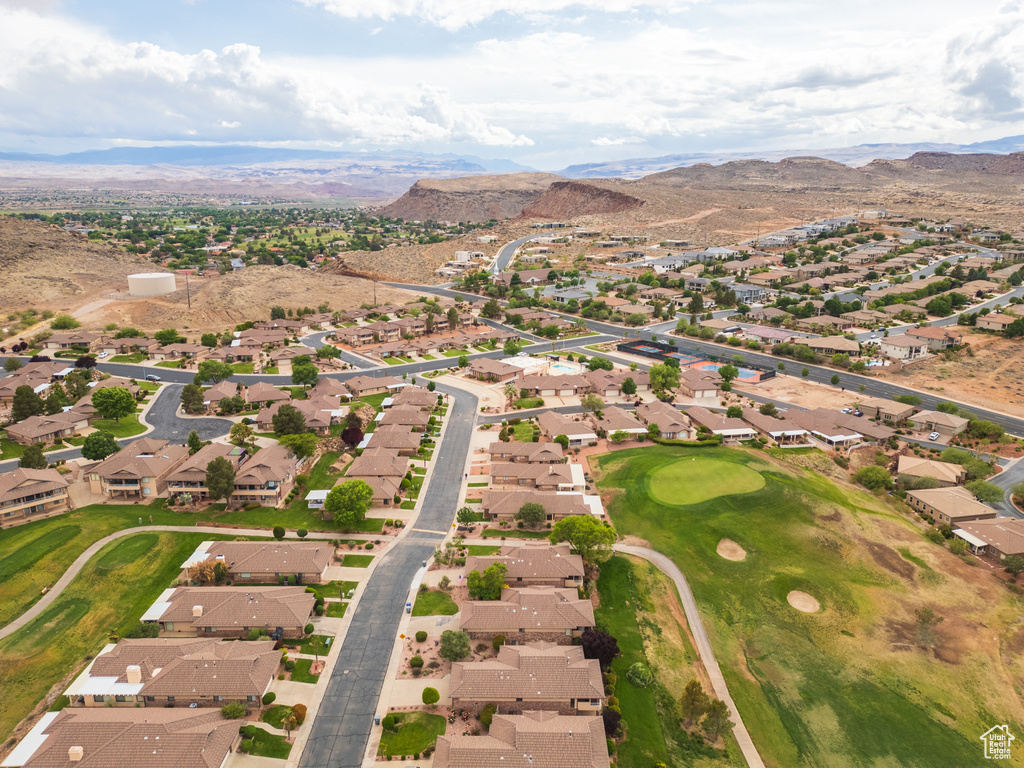 Aerial view of property and surrounding area with nearby suburban area, mountains, and a local golf course