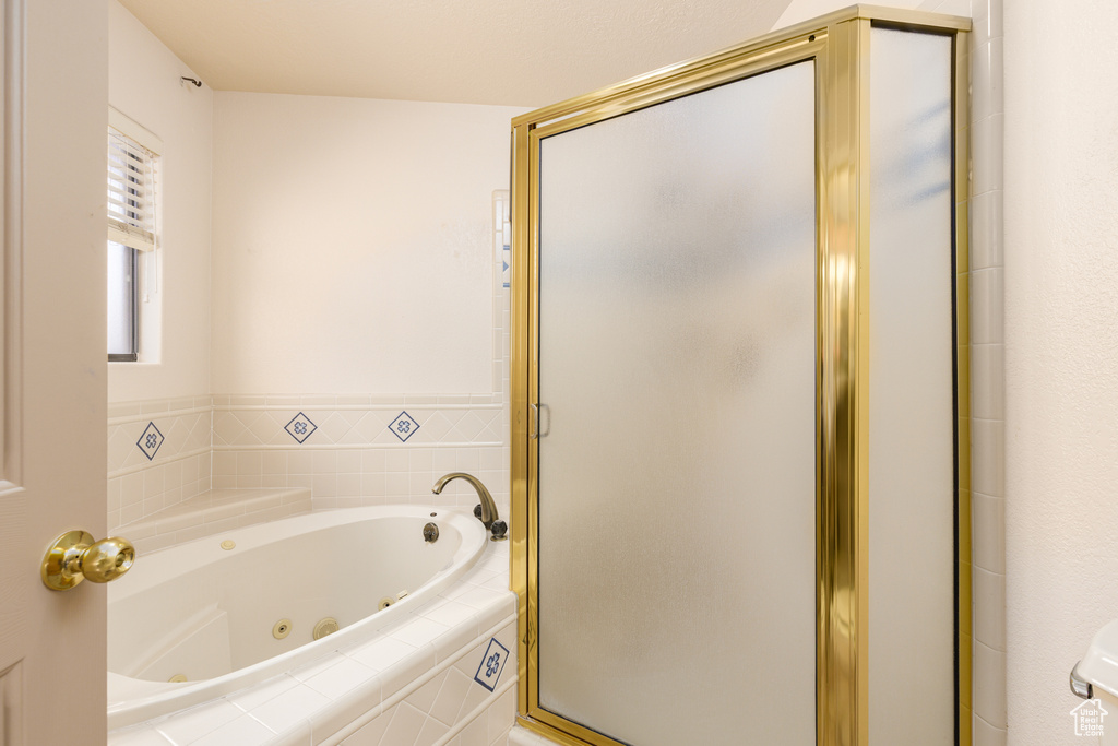 Bathroom featuring a jetted tub and a stall shower