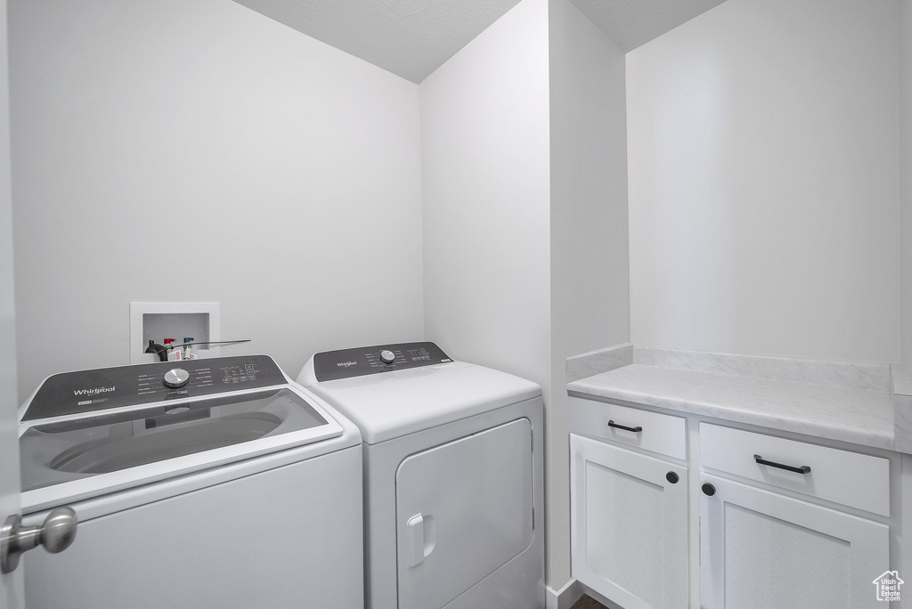 Laundry room featuring washing machine and clothes dryer and cabinet space