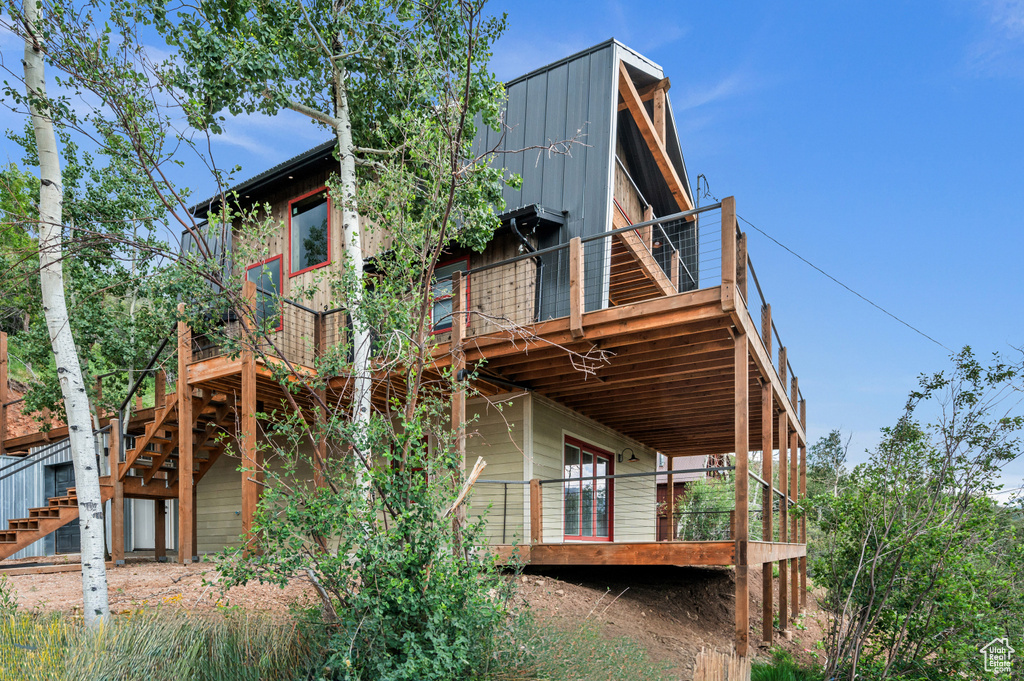 Back of house with stairway and a deck