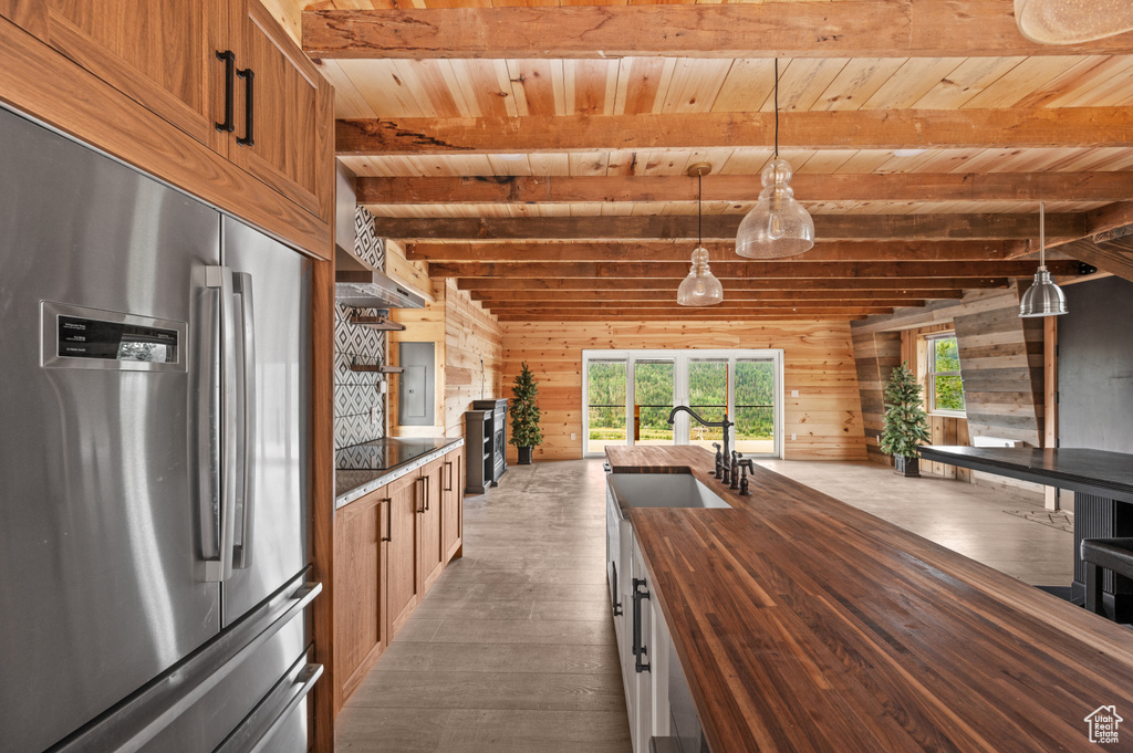 Kitchen featuring stainless steel fridge, butcher block countertops, a sink, wooden ceiling, and hardwood / wood-style floors