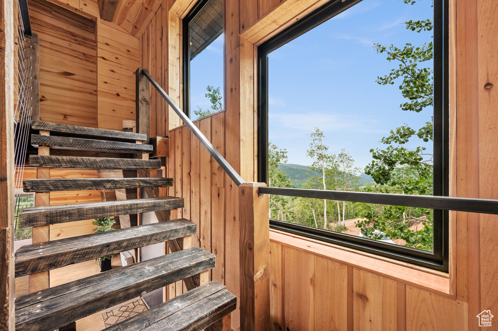 Staircase featuring wood walls