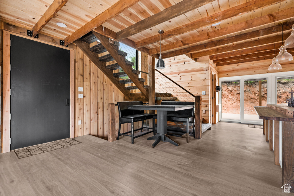 Interior space with stairs, wood walls, wooden ceiling, beamed ceiling, and wood finished floors