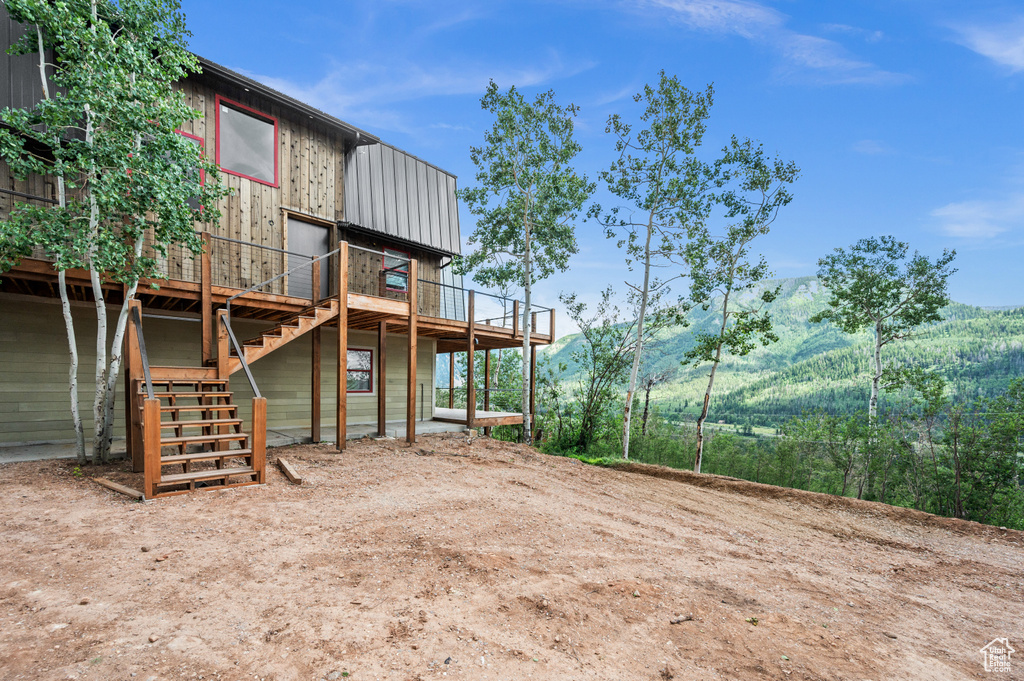 View of yard with a deck with mountain view and stairway